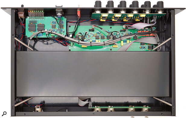 The business end of this reverb is hidden in a spring‑mounted black metal case (under a foam spacer that’s been removed for this photo), with the sensitive pickups shielded by mu‑metal from magnetic interference.