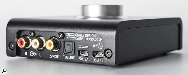 The rear panel hosts unbalanced line outputs, coaxial and optical S/PDIF inputs, and USB ports for power and interfacing. The m900 can be bus‑powered but is capable of higher levels when plugged into a separate mains supply.