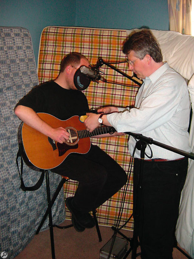 Placing acoustic foam, a thick duvet or, as seen here, some mattresses in a corner behind the performer helps to stop the reflected room sound from entering the microphone.