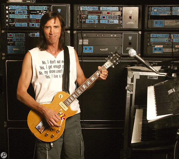 Tom Scholz, with his wall of Rockman gear.