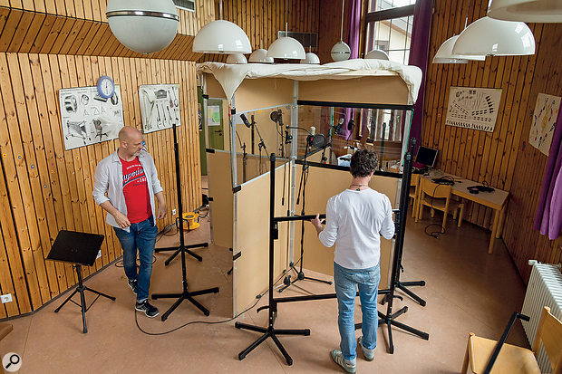 To absorb some of the room sound coming from above each singer, a  thick double duvet was suspended across the top of the baffle. Notice the pine cross-braces supporting the edge of this covering all the way round, as well as the bungee cords securing the duvet and tensioning it to prevent drooping.