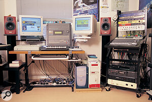 The Ukgaragefm studio. On the desk are the Akai DPS12i, now used solely as a master recorder, and Yamaha Promix 01 digital mixer, flanked by twin computer monitors and Tannoy Reveal speakers. The two studio PCs are below the right‑hand monitor: the one on the left is the custom‑built Area 51 music PC, while the other handles Internet duties.