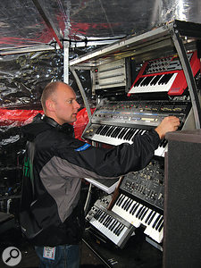 Matt Cox tunes up a Roland Jupiter 6 polysynth prior to the Creamfields show. Note the custom-made covers that keep the gear dry backstage.