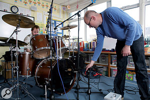 If you can't afford to hire a studio, close-miking and reverb is probably the best option for a roomy drum sound, but you could always try finding a local facility with a larger space — as here, when we used a local school hall!