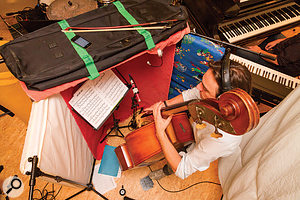 Spill on the upright bass’s close mic was reduced by building a chest‑height baffle out of three mini‑mattresses and a thick rug, as well as by suspending a couple of thick duvets behind the player on a cheap lighting stand.