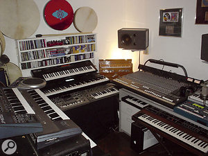 James's area of the studio. Instruments, from left, include Roland JP8000 and Korg N364 synths, Roland Handsonic percussion controller, XP30 keyboard, MC505 groovebox and SH101 analogue synth, harmonium, Korg Electribe groovebox and Sequential Prophet 5 synth.