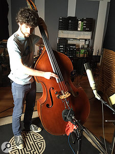 Michael League tracks an upright bass part, miked with a  Telefunken ELA M251 above the instrument, a  Coles 4038 in front and an AKG C451 wedged into the bridge. All three mics were used in the mix.