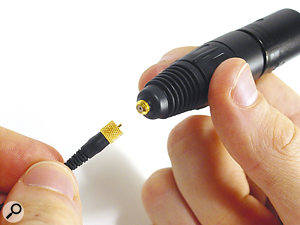 The miniature mic's diminutive screw-lock connector interfaces with normal mic inputs via an XLR adaptor.