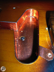 Left: A small tag of copper foil is used to continue the screening onto the underside of the shielded scratchplate. Passing one of the scratchplate screws through it ensures consistent contact.