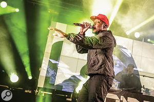 Dizzee Rascal performs in front of an LED wall.