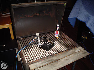 Another way to get a novel guitar sound: the mic is taped to a barbeque grille and a miniature amp is rested on it.