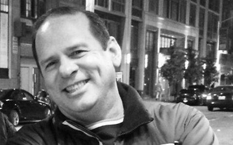 Paul DaCruz smiling and wearing his favourite Porsche jacket. Paul DaCruz smiling with arms crossed wearing his favourite Porsche jacket.